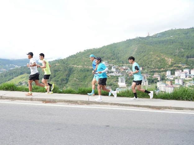 Runners doing interval training on the ridge road above the Thimphu valley